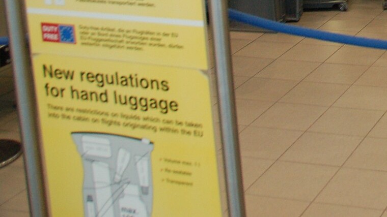 空港の「機内持ち込み手荷物の新しい規則」を示す案内板