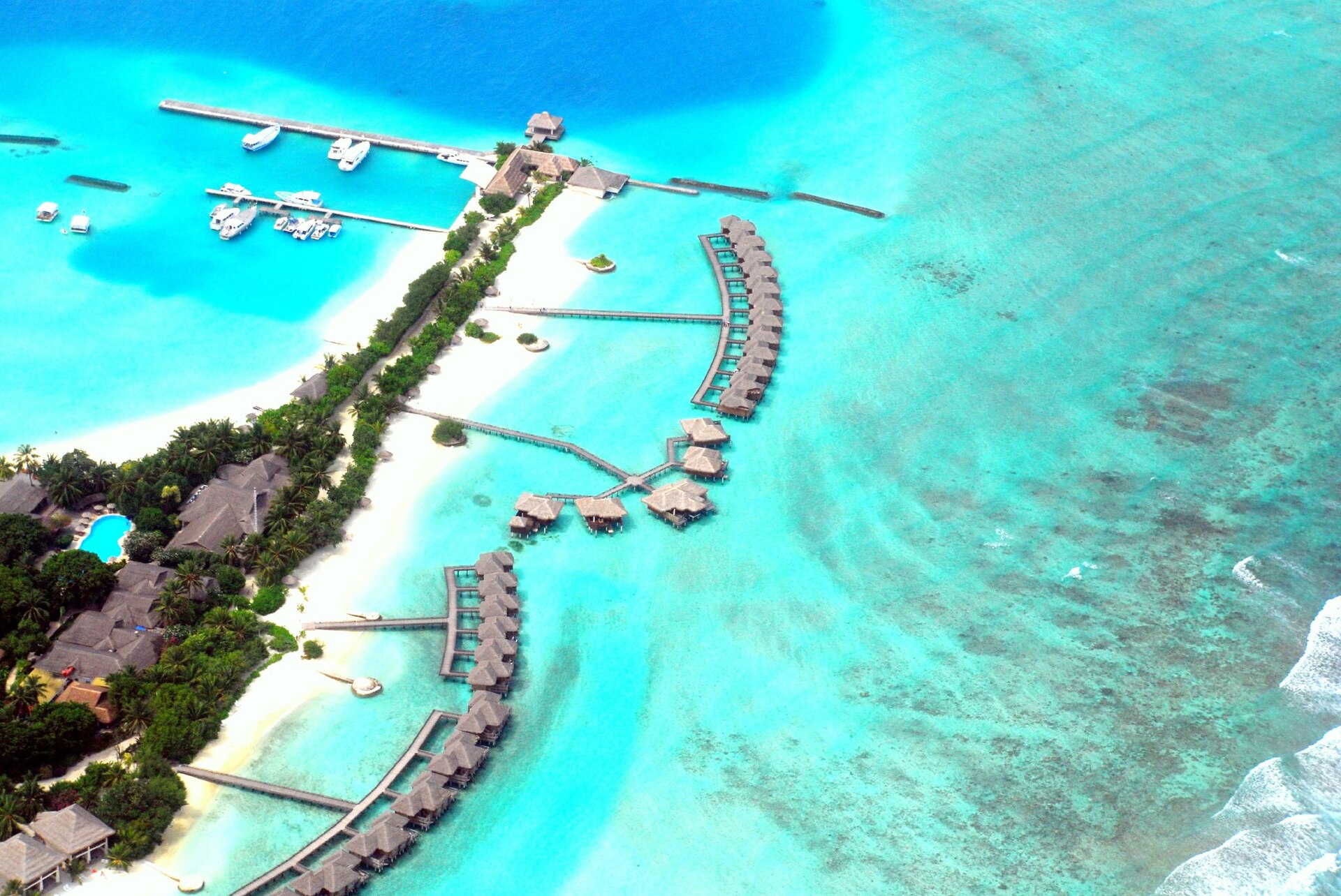 Maldives resort island water villas aerial